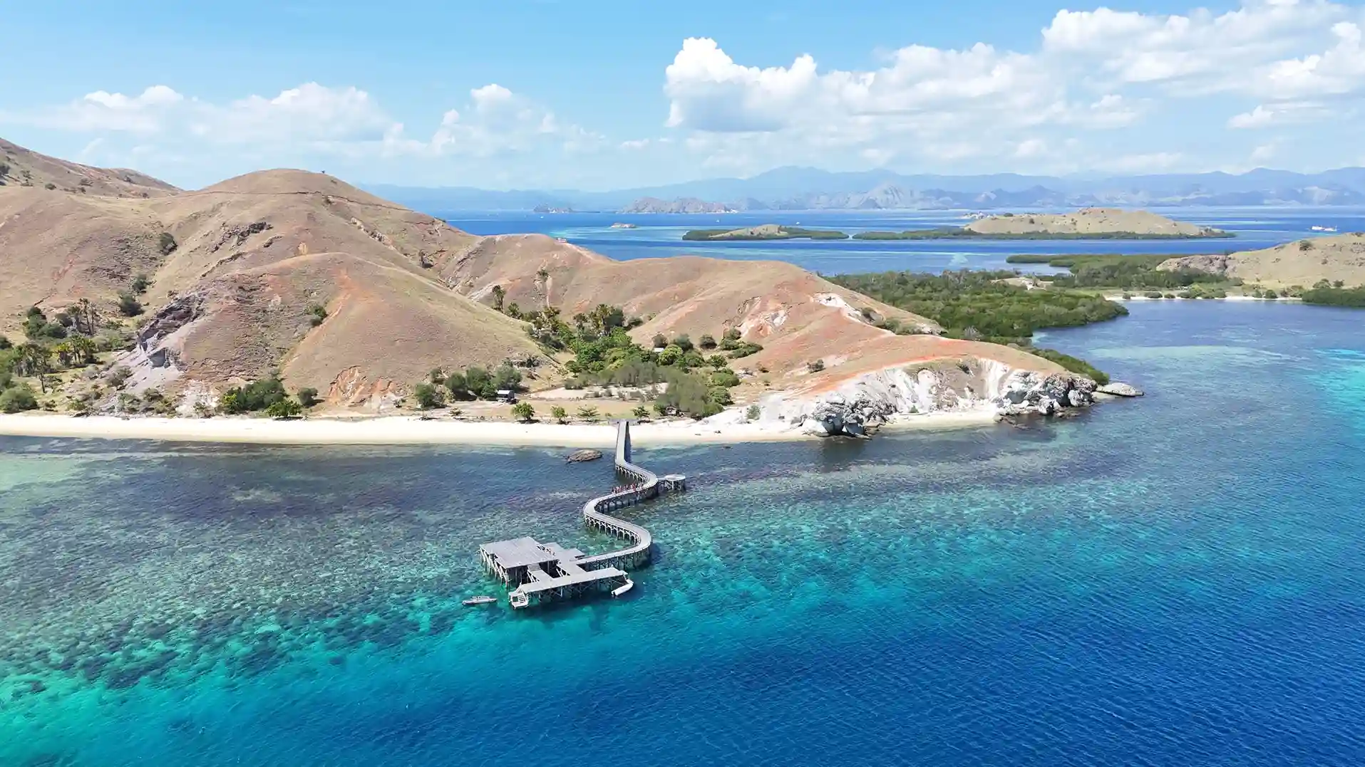 Aerial view of Sebayur Island with a boat moored offshore