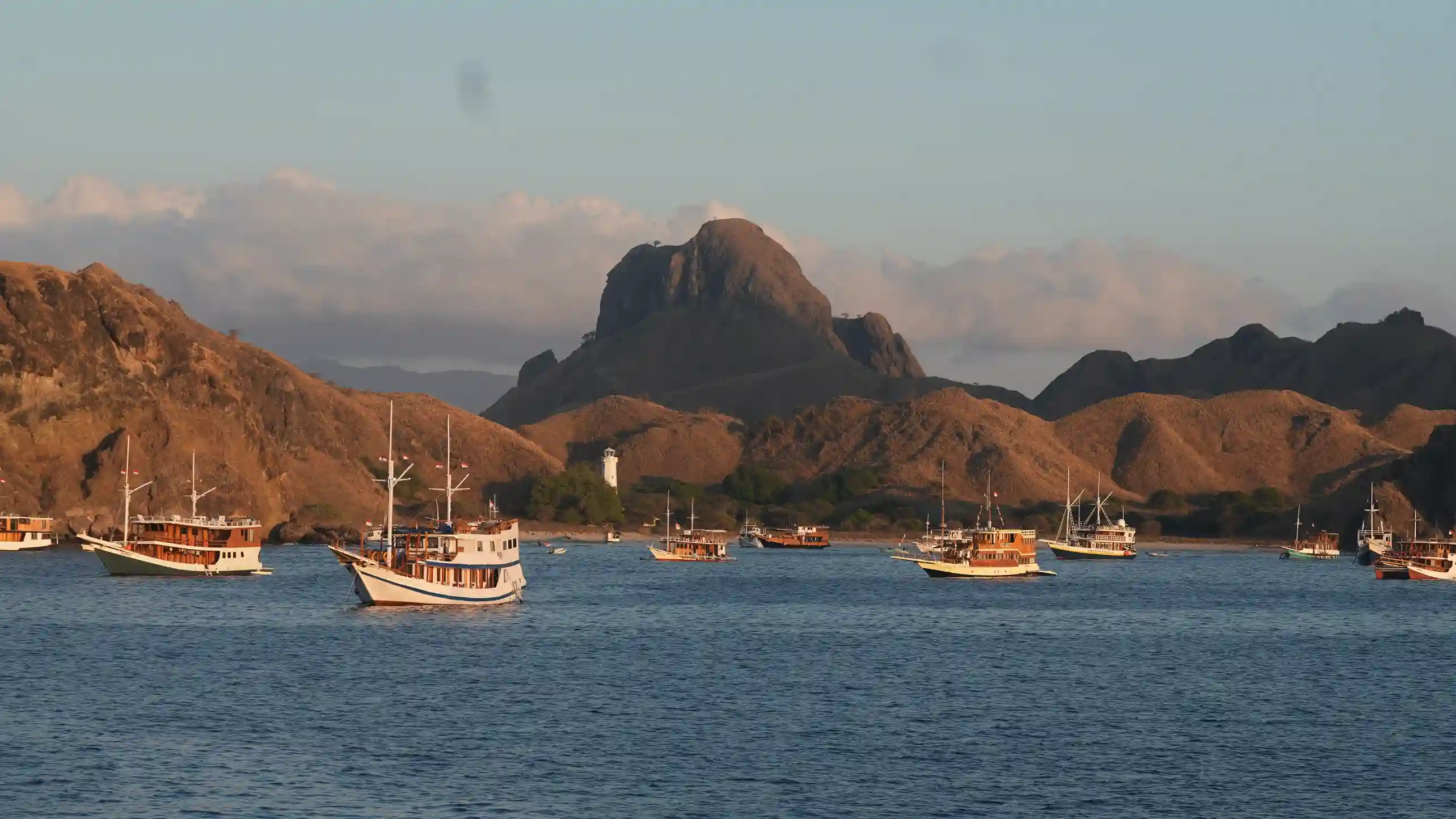 Phinisi yachts at anchor below the hills of Komodo Island